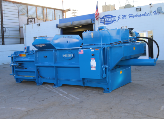 a brand new bright blue Baletech baler pictured outside of the Baletech J.M. Hydraulics building in Sun Valley, California