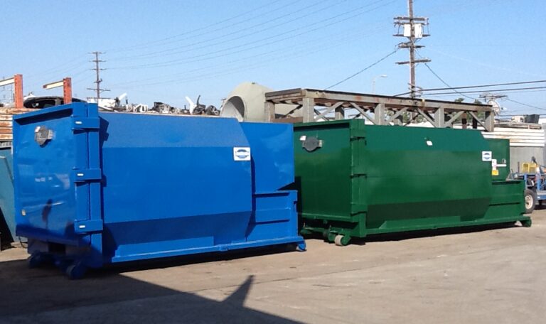 a blue and a green compactor stand outdoors next to each other